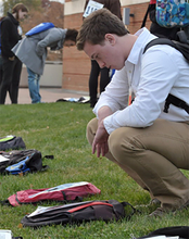 Student looking at backpack on the ground