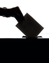 Hand putting ballot in box