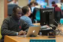 Man sitting at a desk looking at a laptop