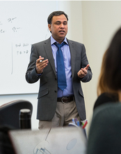 UIS professor Mohammed Mohi Uddin teaching a class using hand gestures in a classroom. 