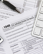 1040 tax form with a pen and computer keyboard.