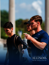 Three men walking outdoors, one pointing ahead, with tall columns in the background.