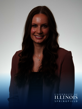 Smiling woman in a blazer. Blue, hombre box at the bottom with the logo University of Illinois Springfield.