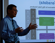Man presenting data flowchart on screen.