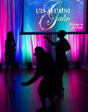 Silhouetted dancers at a colorful gala event.