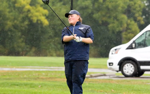 Peyton Woods golfing in the rain in UIS gear