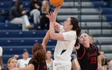 Brooke Spychalski playing basketball in white UIS uniform