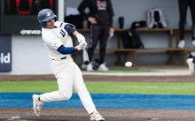 Tommy Atkinson playing baseball in white UIS uniform