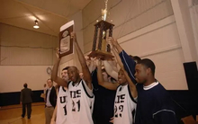 UIS Basketball Players Hoisting Trophy