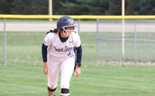 Jaden Watts playing softball in white UIS uniform