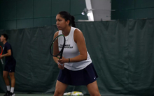 Cristina Mendoza Romero playing tennis in blue and white UIS uniform