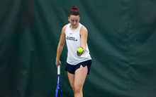 Jane Carter serving in UIS tennis match
