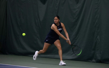 Cristina Mendoza Romero playing tennis in blue UIS uniform