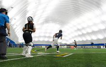A photo of Bailey Masching and others running the bases at softball tournament in Scheels Sports Dome