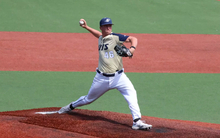 Brayden Mayer pitching for UIS baseball in gold uniform