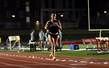 Mackenzie Billard running outdoor track in the evening in blue UIS uniform
