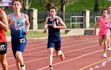 Garrett Wagoner running outdoor track in blue UIS uniform