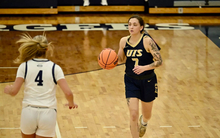 Kennedy Osterman playing basketball in blue UIS uniform