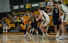 Jordan Rice playing basketball in blue UIS uniform in Missouri S&T gym