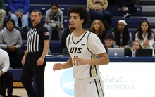 Donaven Younger playing basketball in white UIS uniform