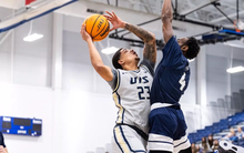 Tye Banks playing basketball in gray UIS uniform
