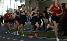 UIS men's track athletes running an indoor race