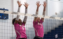 UIS volleyball block, pink jerseys