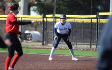 Calista Stahlhut on first base in white UIS uniform