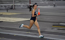 Madelyn Miller-Ross running indoor track in blue UIS uniform