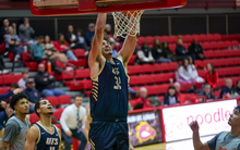 Alex Stell dunking a basketball at UMSL