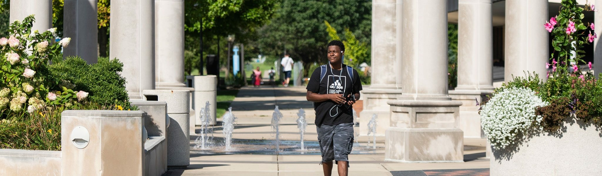 student in front of colonnade