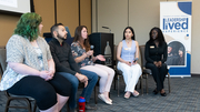 Panel discussion with five seated people in a conference room.