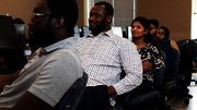 People seated in a classroom, attentively looking forward.