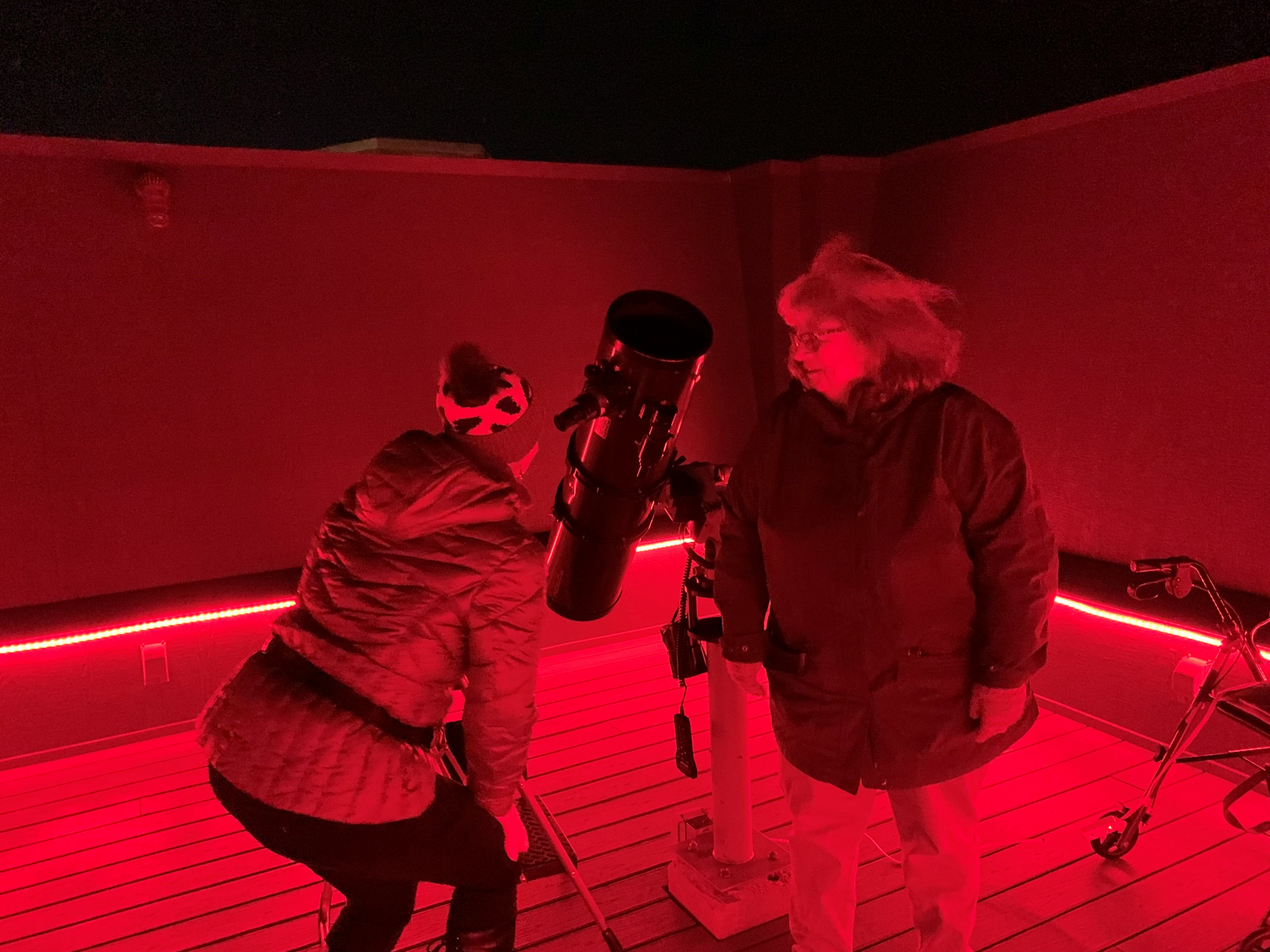 UIS employees observe the sky through a telescope.