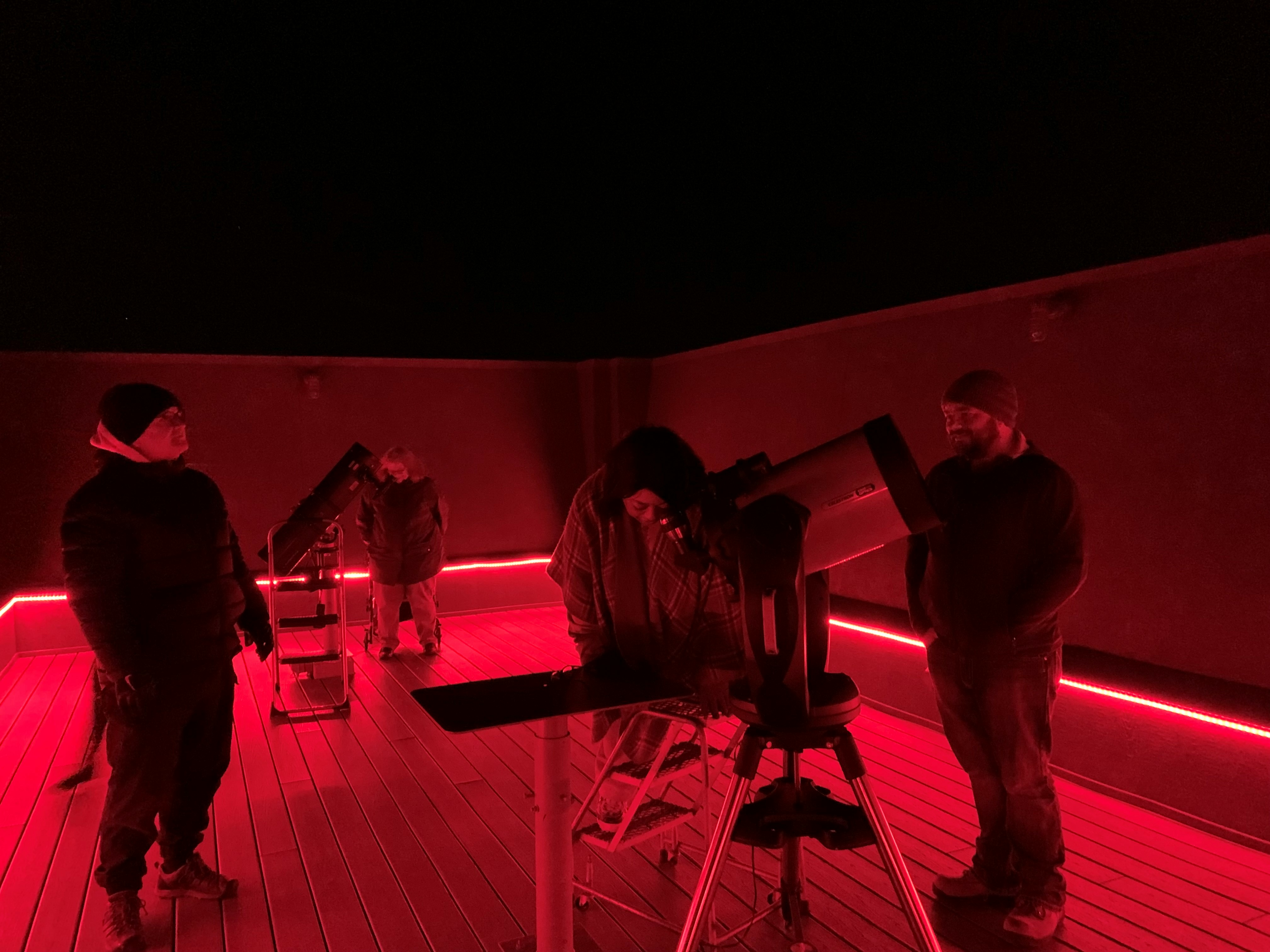 UIS employees observe the sky through a telescope.