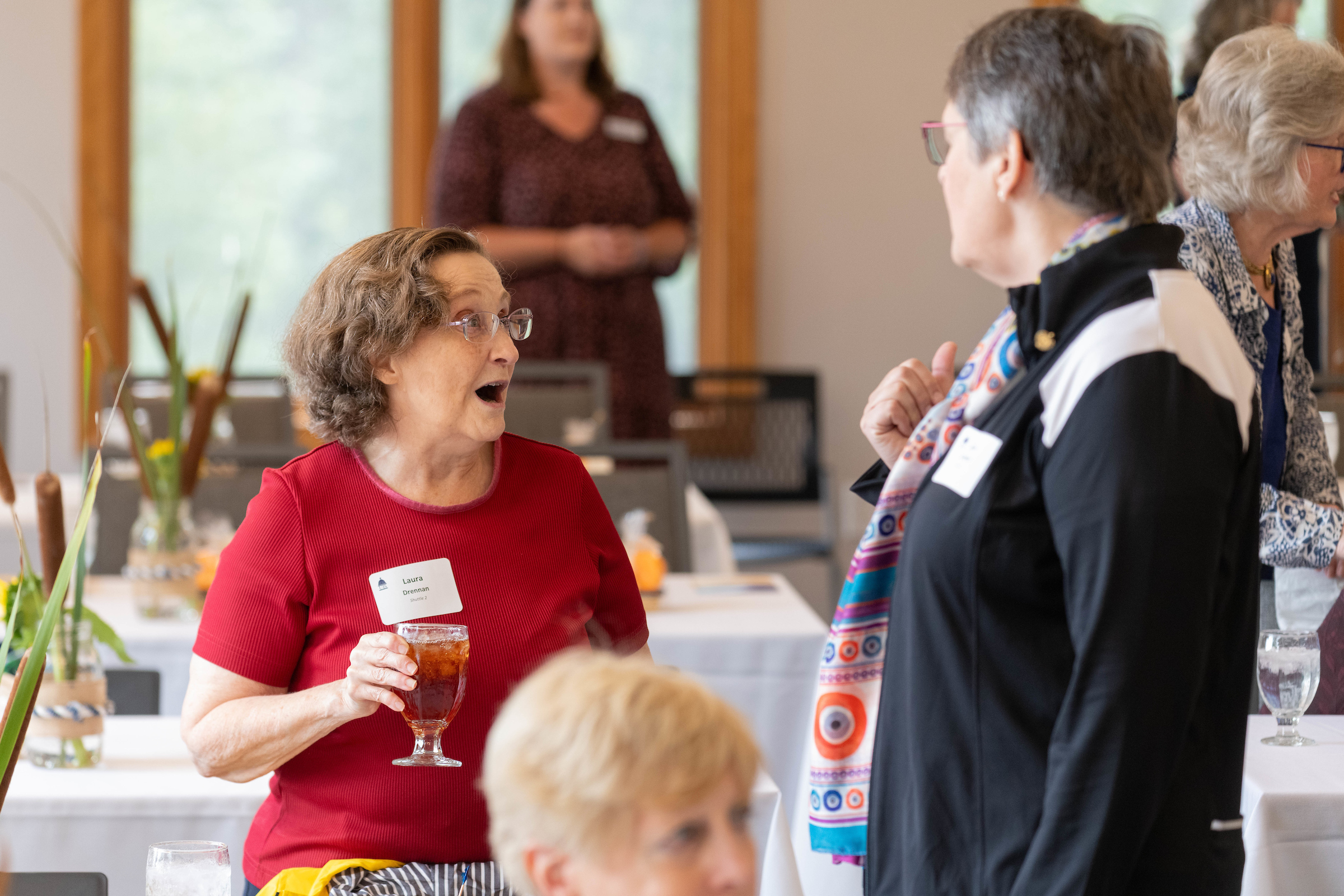 Two women talking to each other during a luncheon event