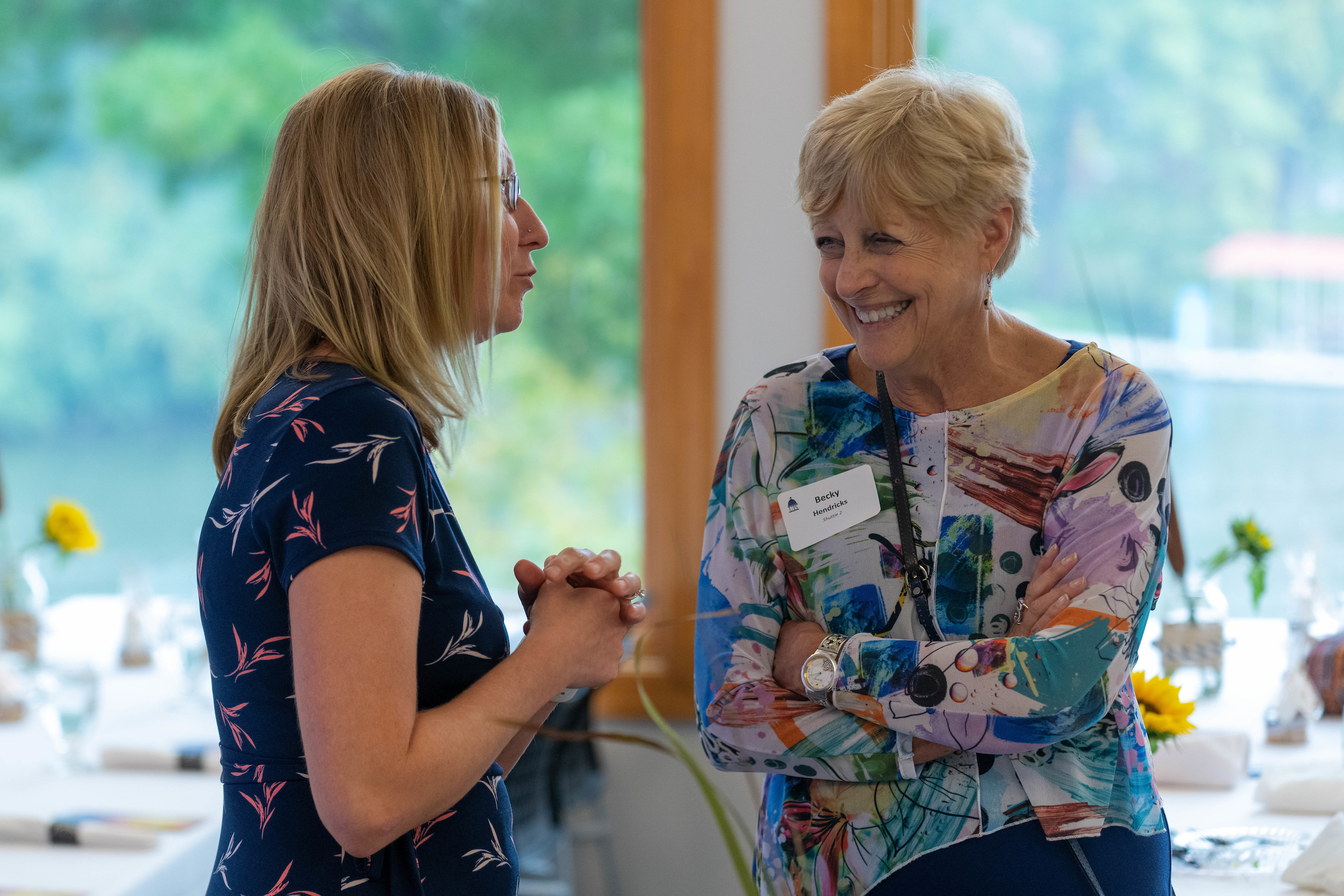 Two women talking to each other during a luncheon event