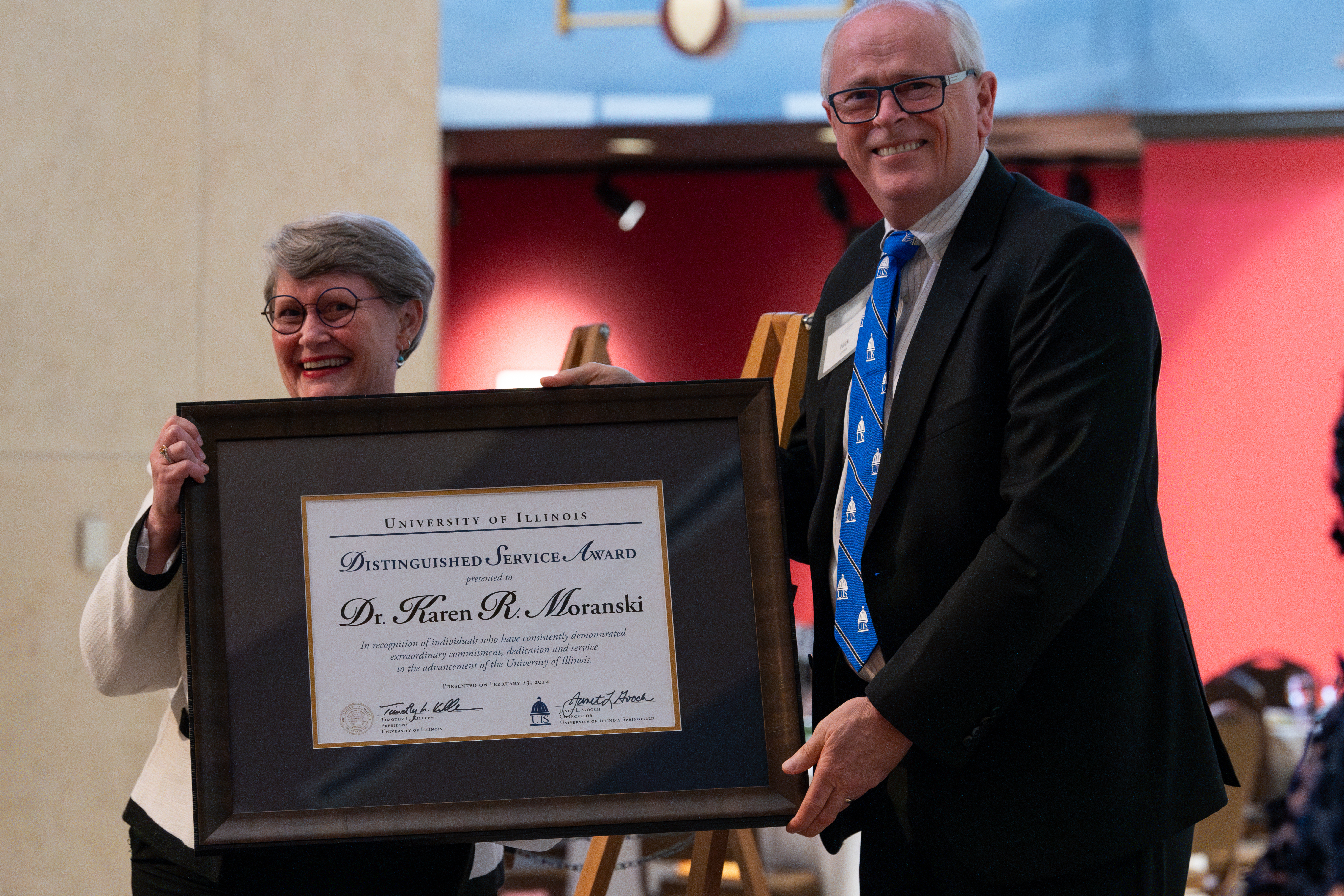 Karen Moranski receives her award on stage from University of Illinois System Vice President Nick Jones