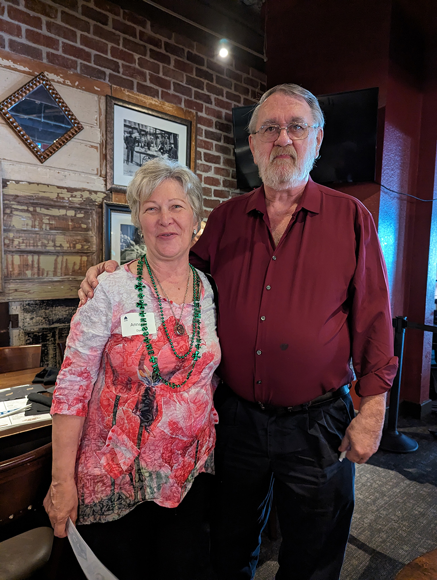 A man and woman pose for a picture in a restaurant
