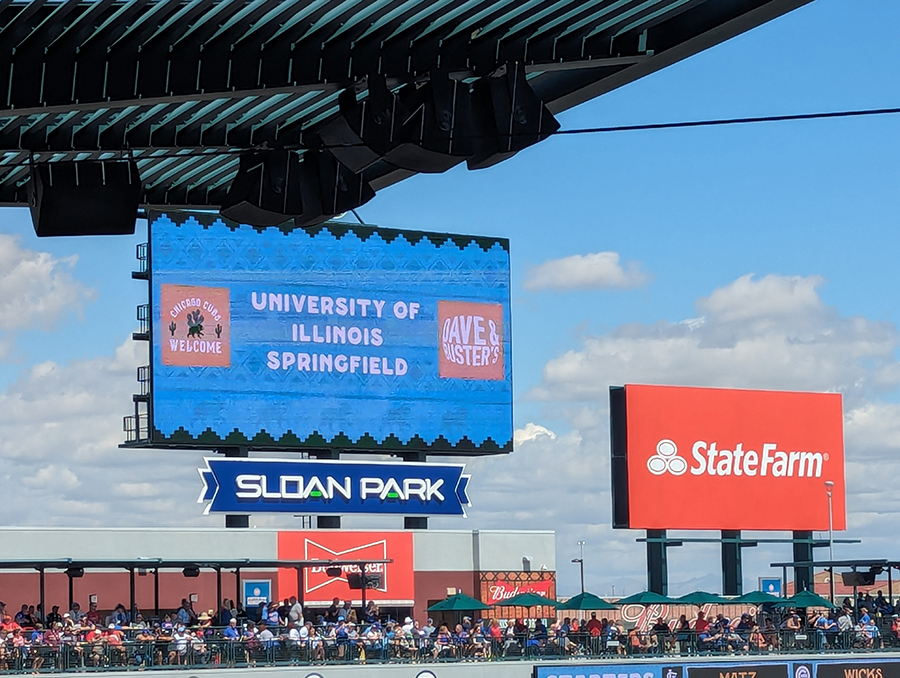 a changing billboard at a baseball game says University of Illinois Springfield