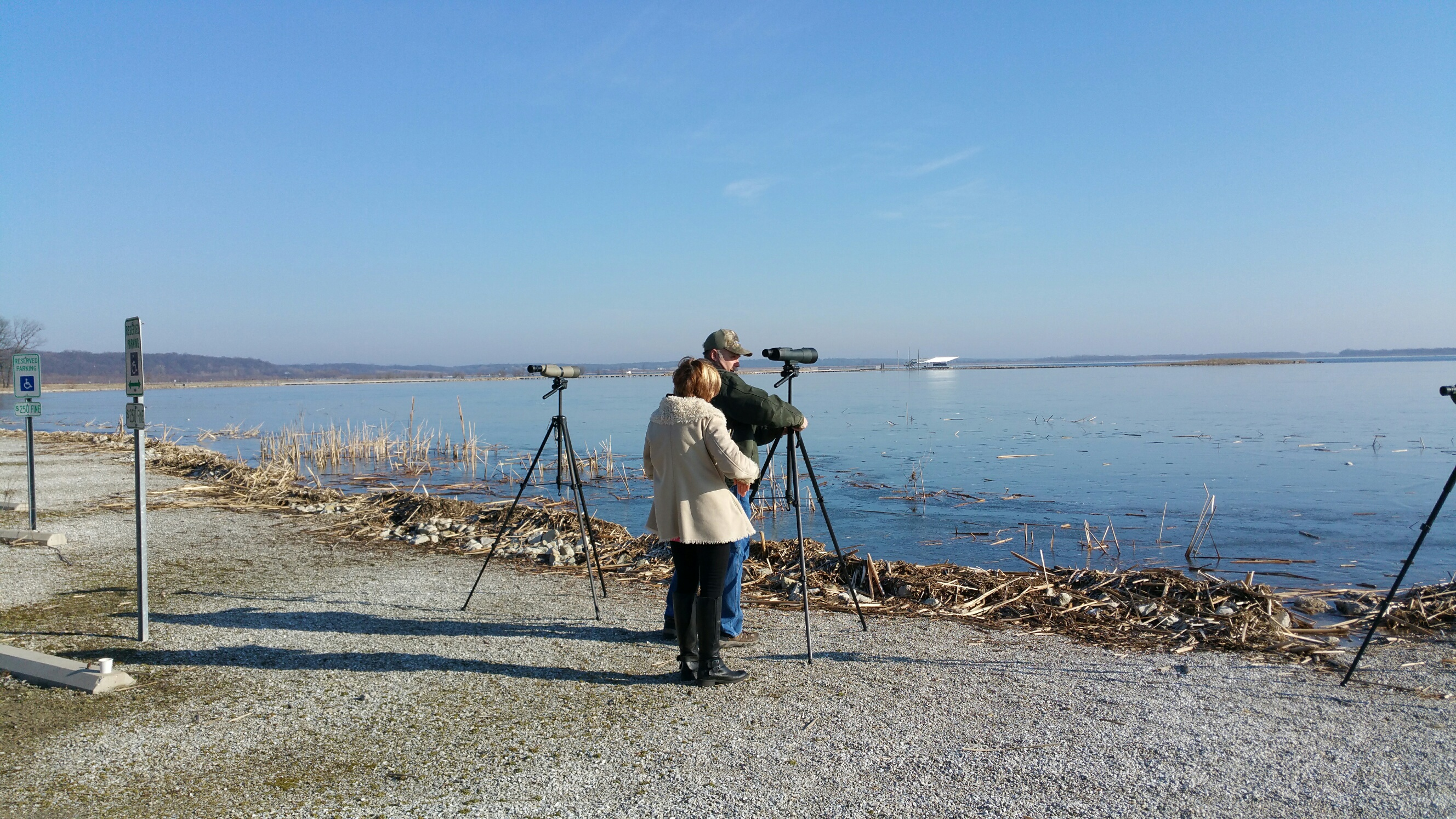 People using spotting scopes at a lake