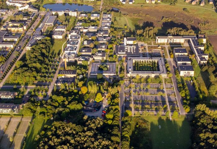 Aerial view of Rosklide campus. Gray square buildings surrounded by greenery.