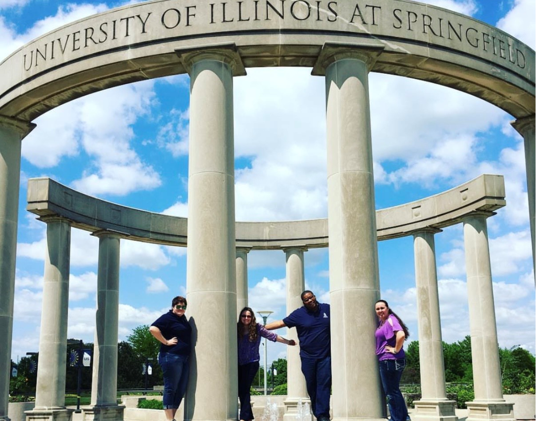 Rex with 3 other students posing for a photo around the colonnade.