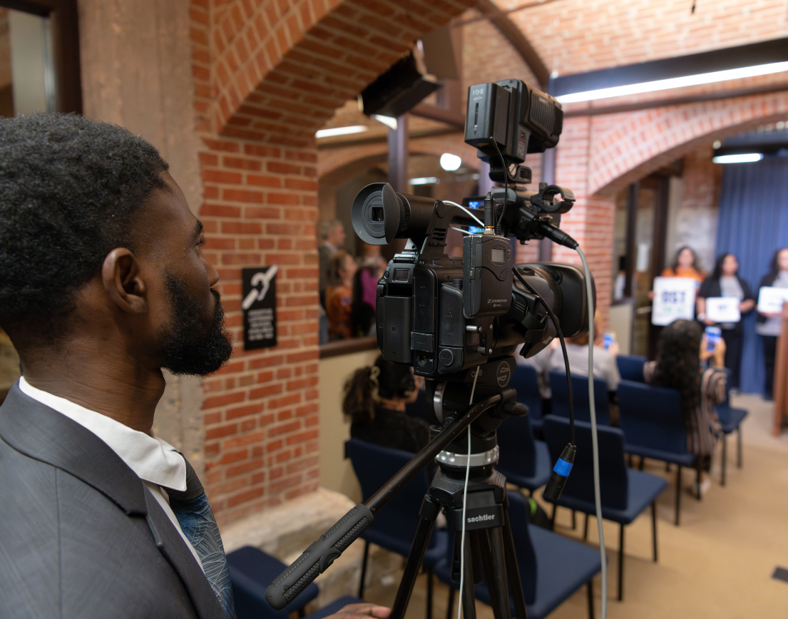 A man filming behind the camera.