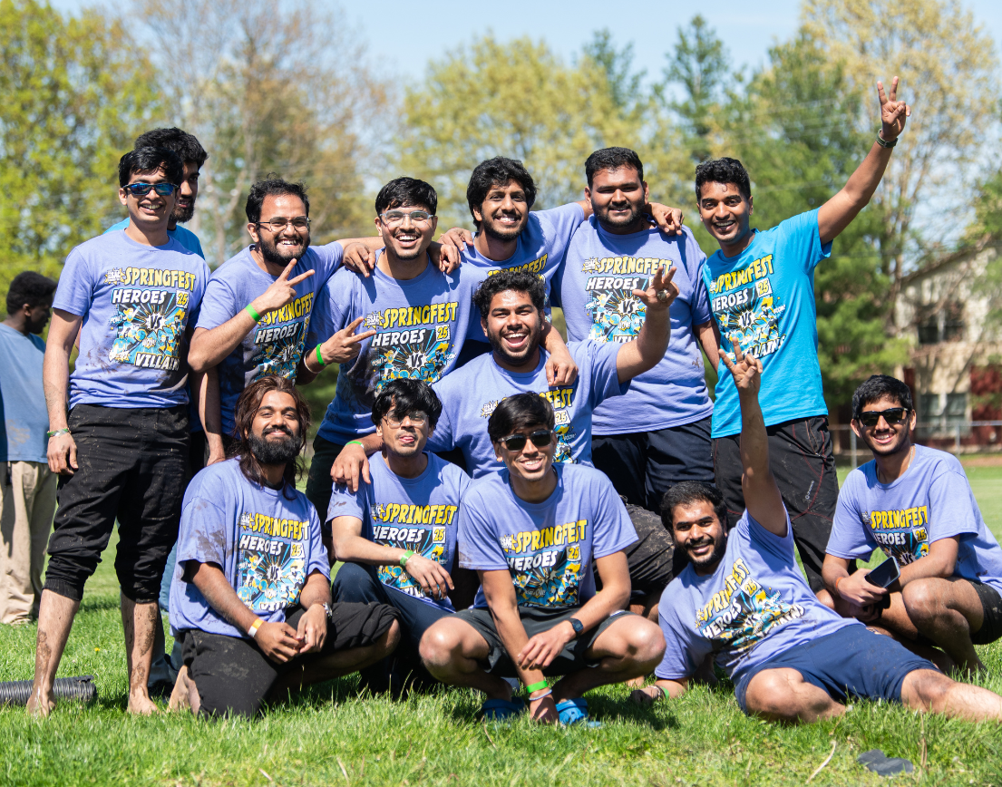 A group of men happily posing for a picture in purple shirts.