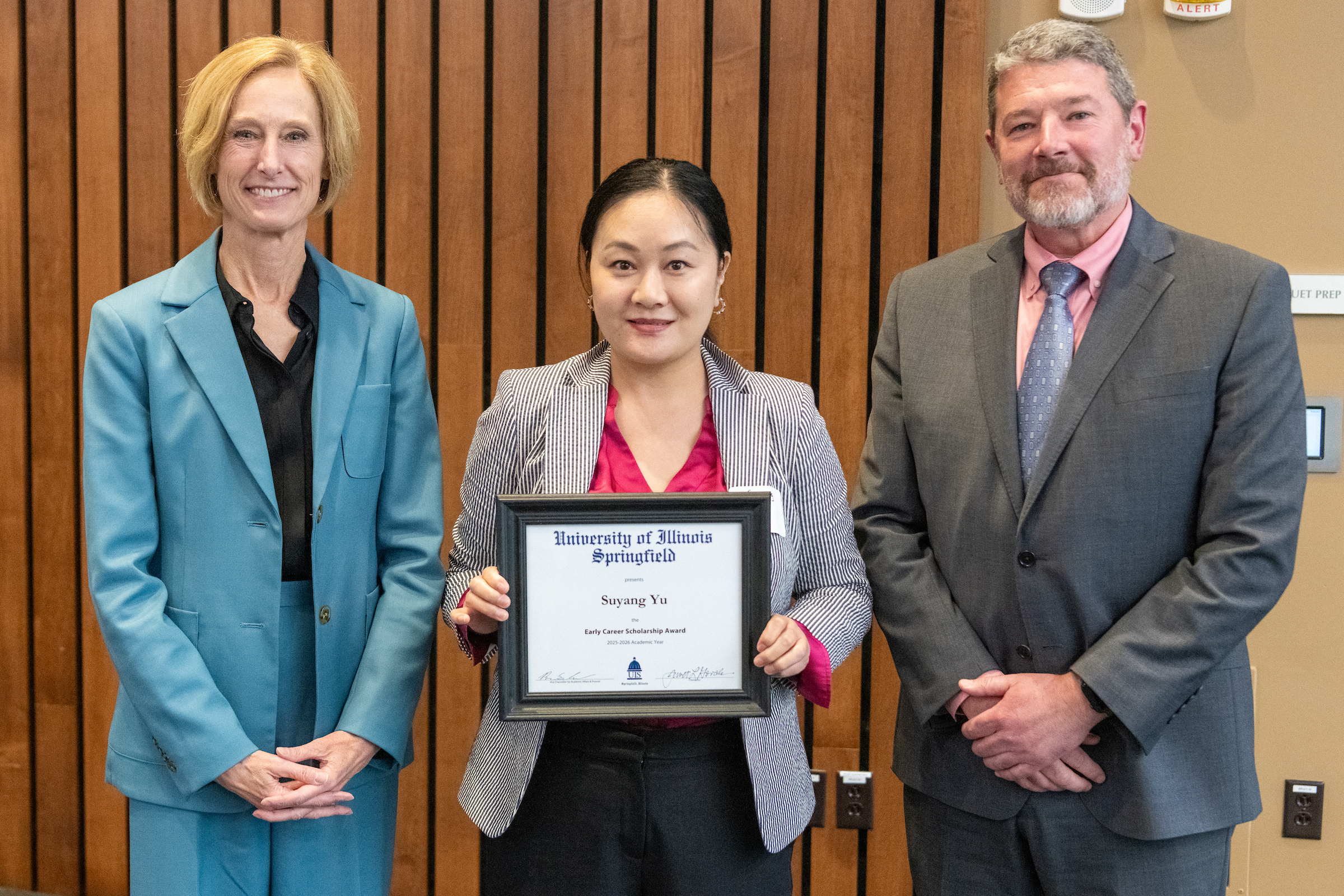 Chancellor Gooch, Suyang Yu with framed award, Provost Schwab