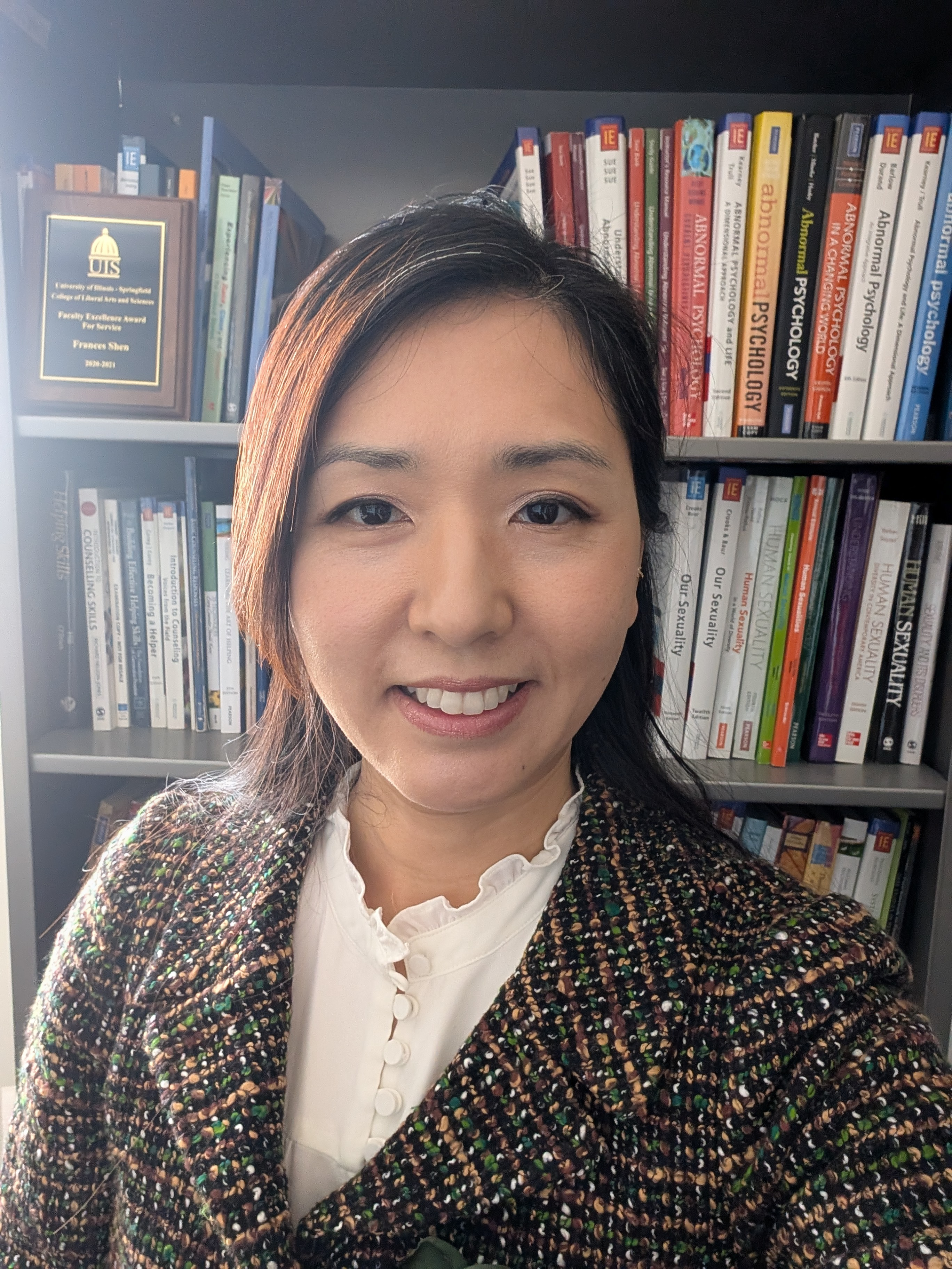Frances Shen in front of bookshelf