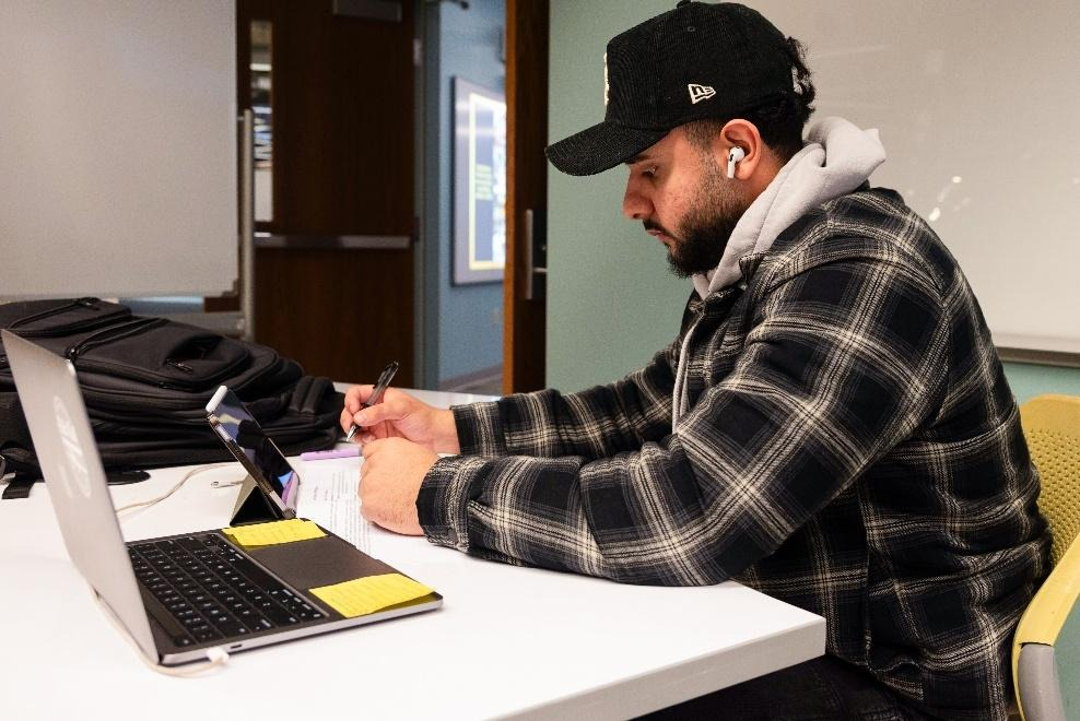 A man studies on a laptop and iPad.