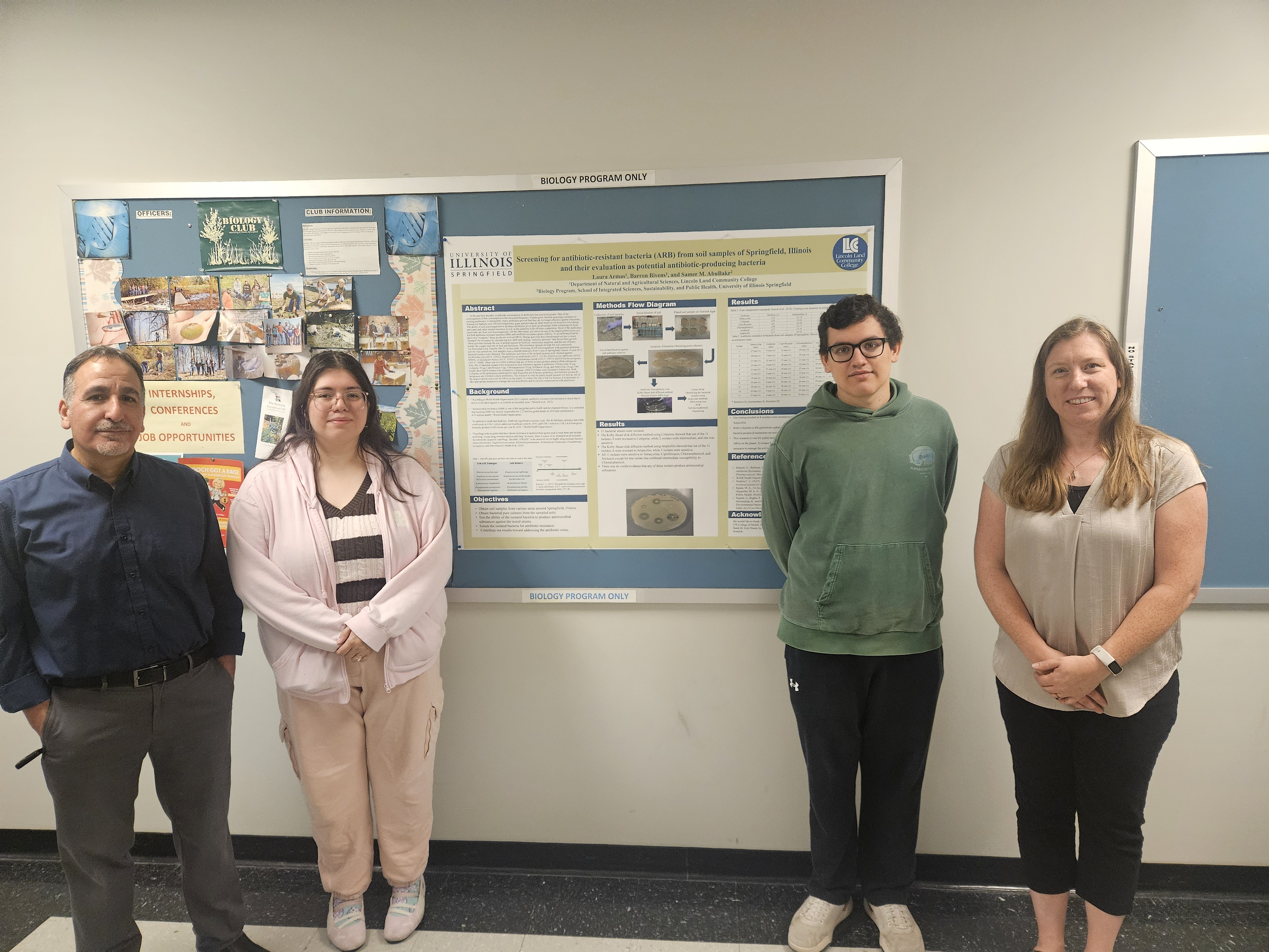 Four students and faculty stand in front of a biology research poster during an undergraduate research presentation.