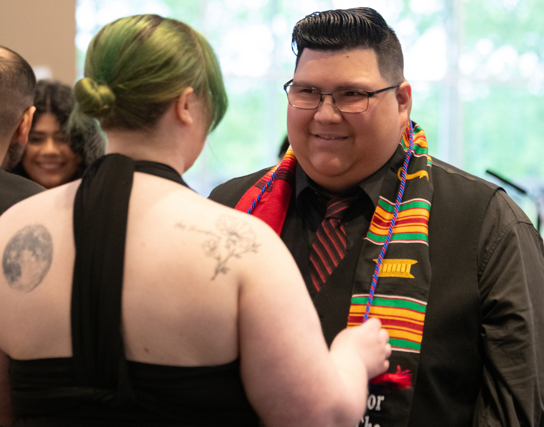 A man receiving colorful stoles and chords.